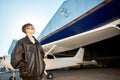 Boy looking thoughtfully, thinking about first flight, dressed in large pilot jacket Royalty Free Stock Photo