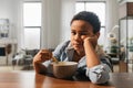 Boy looking to the camera while sitting near the empty plate Royalty Free Stock Photo