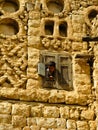 Boy looking to the street behind window, Mahwit. Yemen