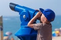 Boy looks at away on sea in monocular on sea beach Royalty Free Stock Photo