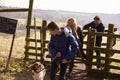 Boy looks down at pet dog during family walk in countryside Royalty Free Stock Photo