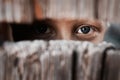 Boy looks through the gap in the fence. The concept of voyeurism, curiosity, Stalker, surveillance and security