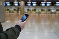 Boy looks at his boarding pass on the mobile waiting at the airport