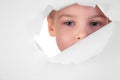 Boy looks in a hole in a sheet Royalty Free Stock Photo