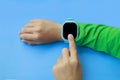 boy looks at information on digital clock pressing screen with his index finger. Modern childrens technologies. GPS tracker for Royalty Free Stock Photo