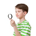 The boy looks through a magnifying glass