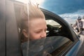 The boy looks out of the car window. The child's hair is blown by the wind Royalty Free Stock Photo