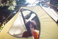 A boy looks out of a tent