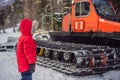 A boy looks at a snowcat at a ski resort