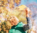 Boy looks on sun light with yellow maple leaf Royalty Free Stock Photo