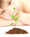 Boy looks at a young plant