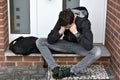 Boy is waiting for someone with front door key