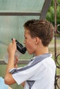 The boy loves to play football, trains with the ball on the artificial turf and scores a goal, the boy is tired and drinks water Royalty Free Stock Photo