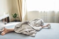 Boy lying on the bed and stopping alarm clock in morning. childs hand reaching for the alarm clock to turn it off Royalty Free Stock Photo