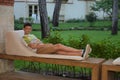 Boy lying on the bench outdoors in the evening. Portrait of teen boy with dark hair. Charming young male in fashionable Royalty Free Stock Photo