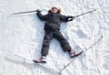 Boy lying in cross-country skis on snow Royalty Free Stock Photo