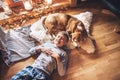 Boy lying on the floor and near beagle dog sleeping on sheepskin in cozy home atmosphere