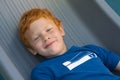 Boy lying on the floor. Portrait European boy with green eyes, looking directly at the camera. Overhead view. Funny