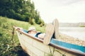 Boy lying in old boat near the lake Royalty Free Stock Photo