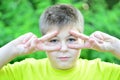 The boy made glasses around his eyes with his fingers Royalty Free Stock Photo