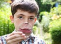 Boy magnify his lips with magnifying glass Royalty Free Stock Photo
