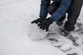 Boy makes big snow ball. Child playing with snow. Winter time outdoor fun Royalty Free Stock Photo