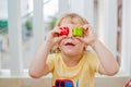 The boy makes eyes of colorful children`s blocks. Cute little kid boy with glasses playing with lots of colorful plastic