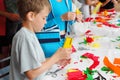 Boy makes flower of tissue paper by stapler Royalty Free Stock Photo