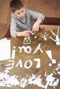 Boy makes origami - car and family, children, parent, I love you text, top view on wood background Royalty Free Stock Photo