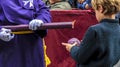 A boy makes a wax ball, dripping from a candle in a procession of Holy Week in Huelva, Spain