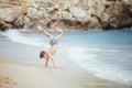 A boy making a cartwheel in the sea surf Royalty Free Stock Photo
