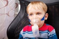 Boy making inhalation with a nebulizer