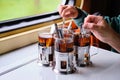 The boy and the man brew black tea in glasses in the cup holders on the table on the train Royalty Free Stock Photo