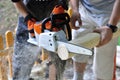 Boy and man with chainsawÃÂ  sawing wood Royalty Free Stock Photo