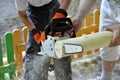 Boy and man with chainsawÃÂ  sawing wood Royalty Free Stock Photo