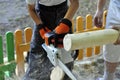 Boy and man with chainsawÃÂ  sawing wood Royalty Free Stock Photo