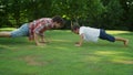 Boy and man standing in plank position. Father and son doing push ups in park Royalty Free Stock Photo