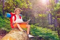 Boy with map sit on stone during hike Royalty Free Stock Photo