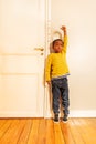 Boy measuring his height benchmark on door at home Royalty Free Stock Photo