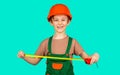 Boy with a measuring tape. Child dressed as a workman builder. Little boy wearing helmet. Little builder in hardhats