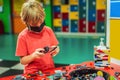 A boy in a medical mask plays with a constructor. child playing and building with colorful plastic bricks table. Early Royalty Free Stock Photo