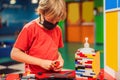 A boy in a medical mask plays with a constructor. child playing and building with colorful plastic bricks table. Early Royalty Free Stock Photo