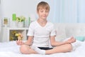 Boy meditating on bed in the morning Royalty Free Stock Photo