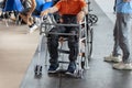Boy with Mobility Problems in Lower Limbs Sitting in a His Wheelchair Ready to Stand Upright Thanks to a Mechanical Exoskeleton