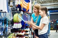 Boy with mom choose badminton rackets at sport store