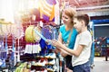 Boy with mom choose badminton rackets at sport store