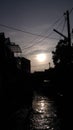 a boy in the morning sun, through the flood waters that inundate a settlement