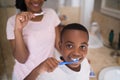 Boy with mother brushing teeth at home Royalty Free Stock Photo