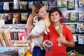 boy with mother choosing dog treats for their puppy Royalty Free Stock Photo