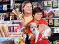 boy with mother choosing dog treats for their puppy Royalty Free Stock Photo